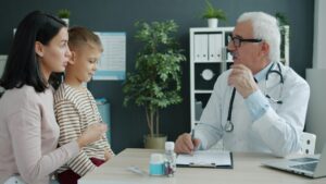 Parent and child reviewing a puberty growth chart together at a kitchen table.