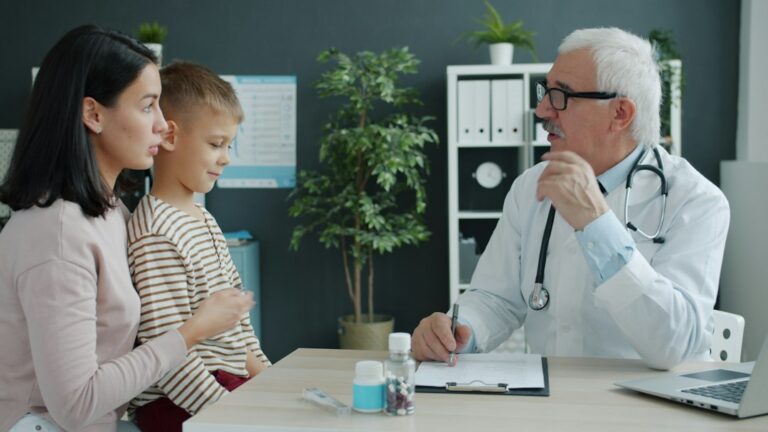 Parent and child reviewing a puberty growth chart together at a kitchen table.